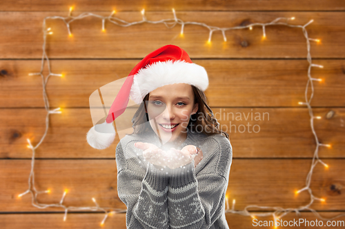 Image of woman in christmas sweater holding magic dust