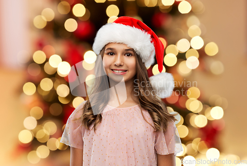 Image of happy teenage girl in santa hat on christmas