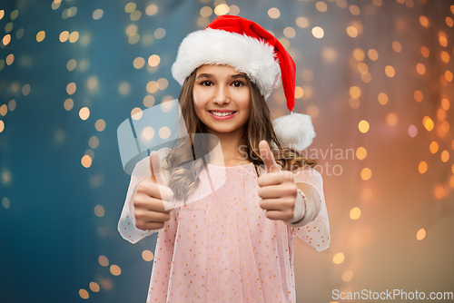 Image of happy teenage girl showing thumbs up on christmas