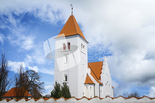 Image of White church in nordic design behind a wall