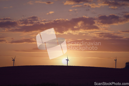 Image of Windmill silhouettes on a hill