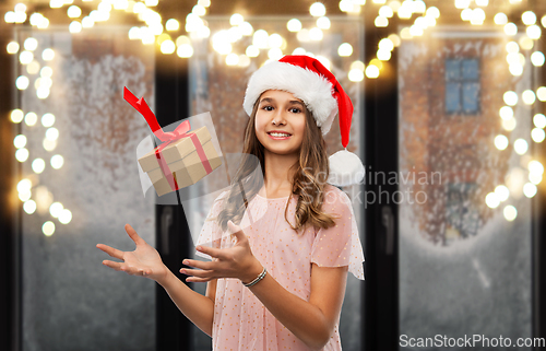 Image of teenage girl in santa hat with christmas gift