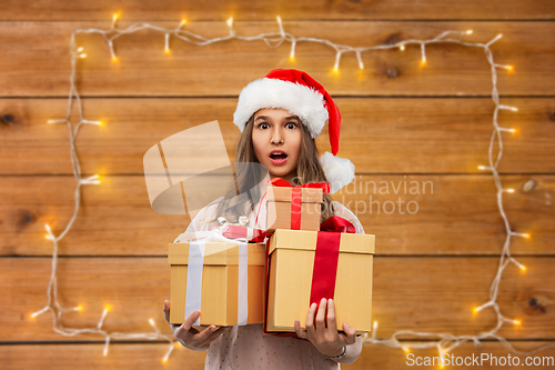 Image of teenage girl in santa hat with christmas gift