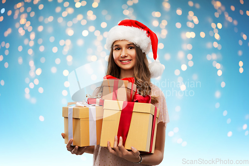 Image of teenage girl in santa hat with christmas gift