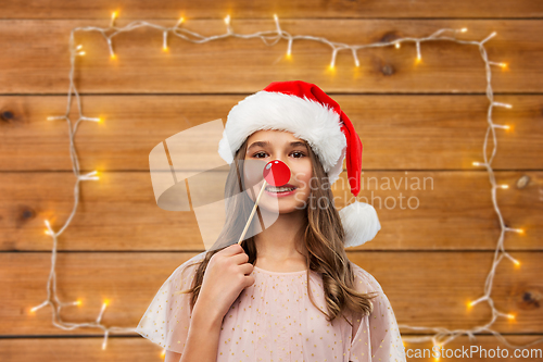 Image of happy teenage girl in santa hat on christmas