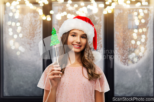 Image of happy teenage girl in santa hat on christmas