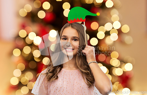 Image of happy teenage girl with santa helper hat accessory