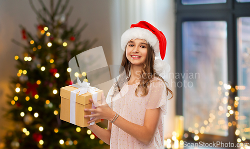 Image of teenage girl in santa hat with christmas gift