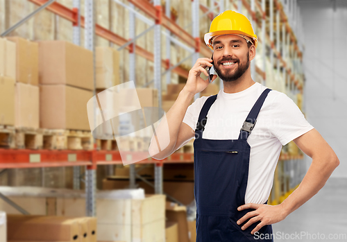 Image of male worker calling on smartphone at warehouse