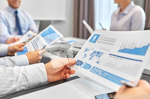 Image of happy business team with papers meeting at office