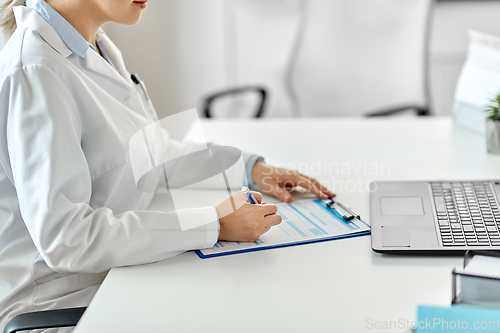 Image of doctor with laptop and medical report at hospital