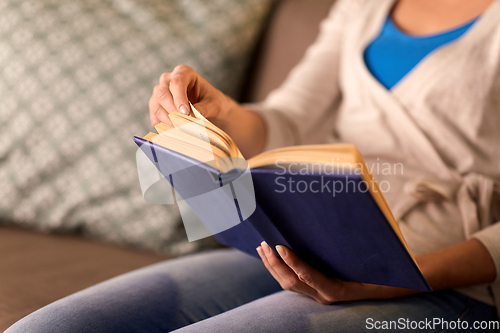 Image of close up of young woman reading book at home