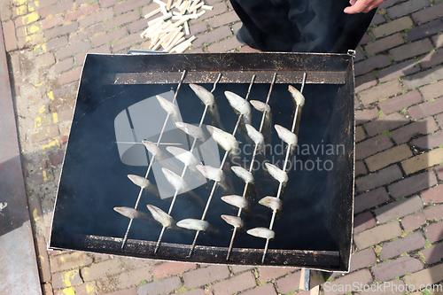 Image of Traditional smoked eels, fish in a smoking in metal barrel