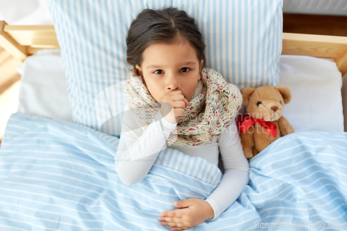 Image of sick coughing girl lying in bed at home