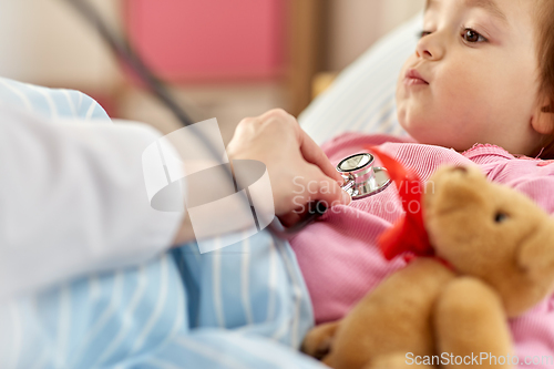 Image of doctor with stethoscope and sick girl in bed