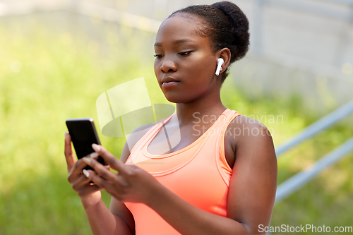 Image of african american woman with earphones and phone