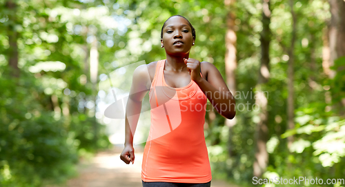 Image of young african american woman running in forest