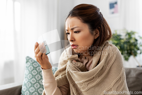 Image of sick asian woman with medicine at home