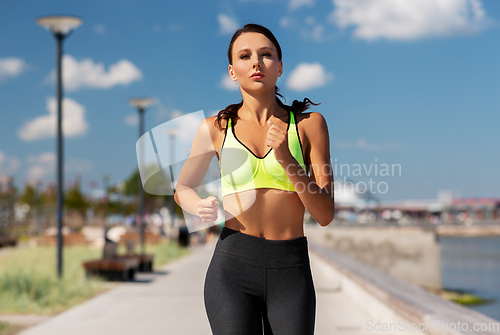 Image of young woman running at seaside