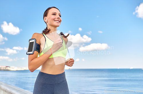 Image of woman with earphones and smartphone running
