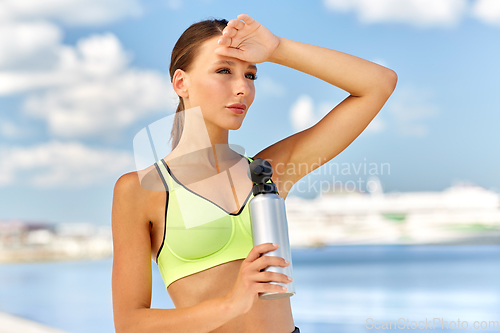 Image of woman drinking water from bottle after sports