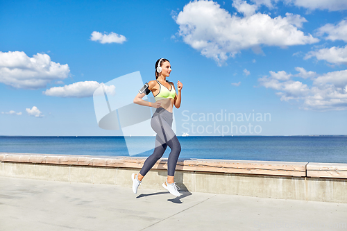 Image of woman with headphones and smartphone running