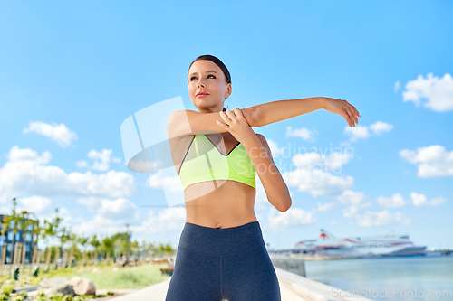 Image of young woman doing sports on sea promenade