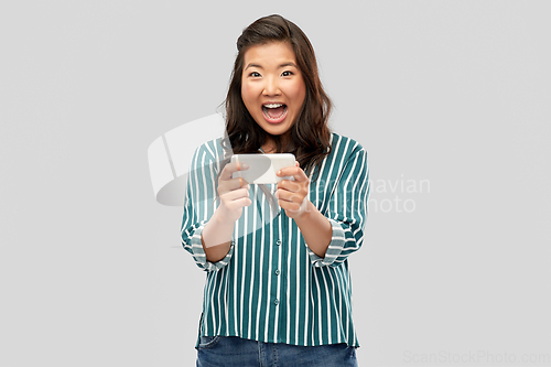 Image of happy asian woman using smartphone