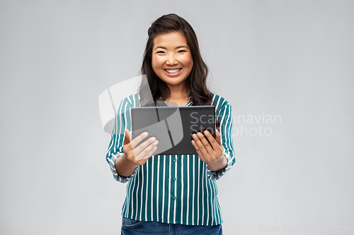 Image of happy asian woman using tablet computer