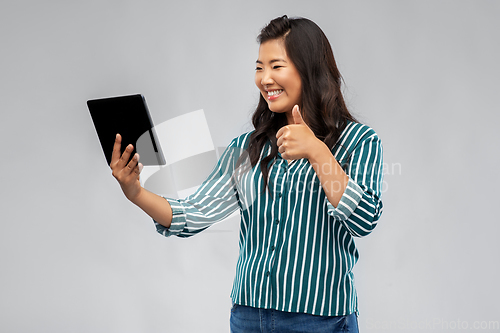 Image of happy asian woman with tablet pc showing thumbs up