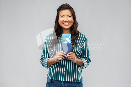 Image of happy asian woman with air ticket and passport
