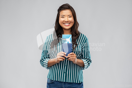 Image of happy asian woman with air ticket and passport
