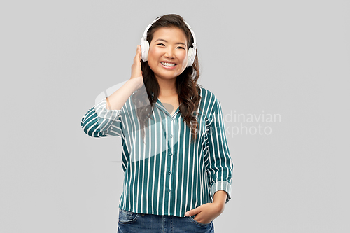 Image of asian woman in headphones listening to music