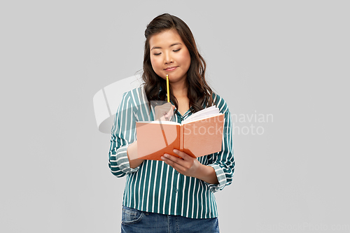 Image of asian student woman with diary and pencil