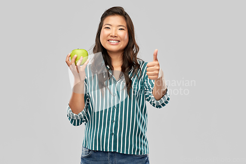 Image of happy smiling asian woman holding green apple