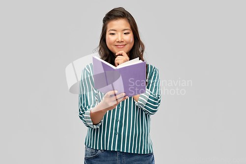 Image of happy asian woman reading book