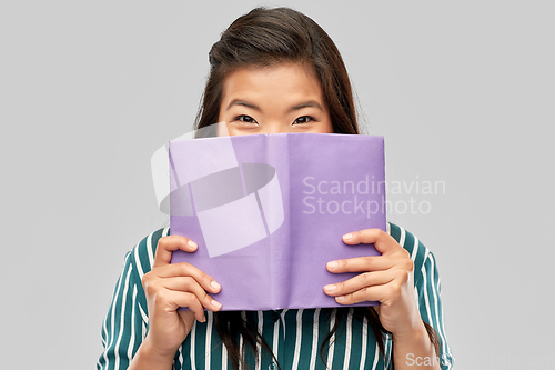 Image of happy asian woman hiding behind