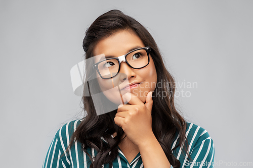 Image of portrait of thinking asian woman in glasses