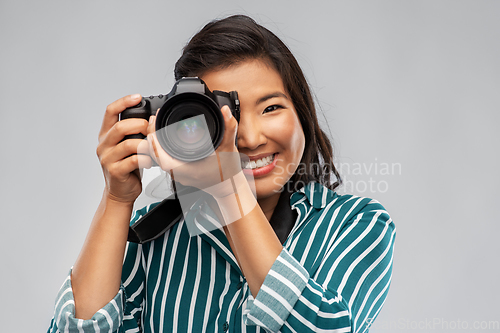 Image of asian female photographer with digital camera