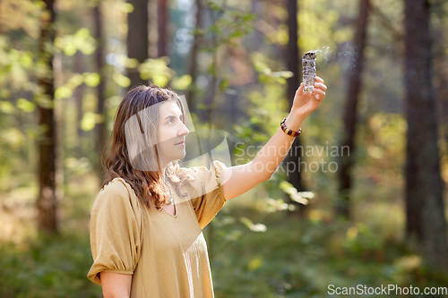 Image of woman or witch performing magic ritual in forest