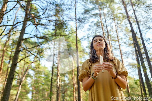 Image of woman or witch performing magic ritual in forest