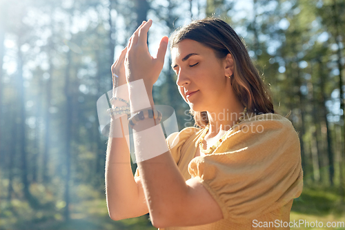 Image of woman or witch performing magic ritual in forest