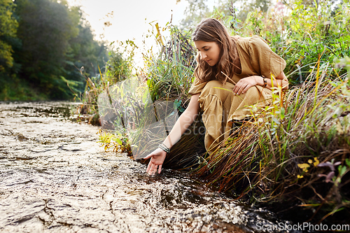 Image of woman or witch performing magic ritual on river