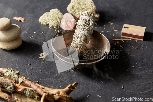 Image of smoking white sage in cup and other magic staff