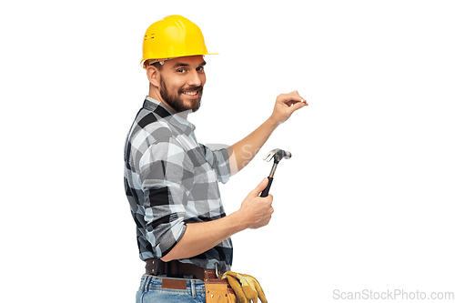 Image of happy male builder in helmet with hammer and nail