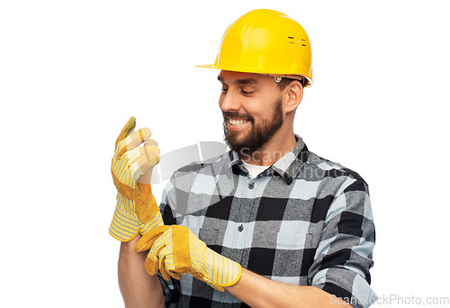 Image of happy male worker or builder in helmet and gloves