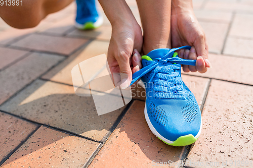 Image of woman fixing the shoelace