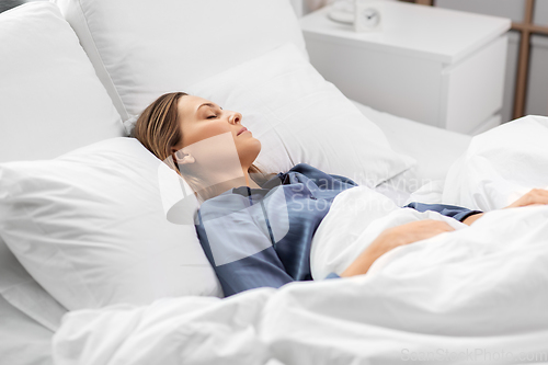 Image of young woman sleeping in bed at home