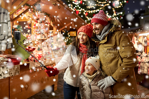 Image of happy family taking selfie at christmas market