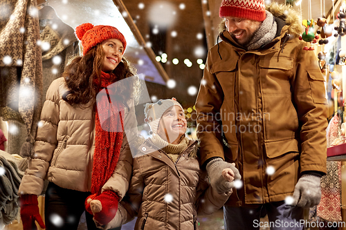 Image of happy family at christmas market in city